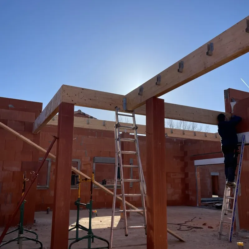 Poteaux et poutres bois en cours de pose sur une extension – Occi'Dry Services